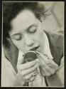 [Woman applying lipstick]
