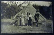 [Six people posing in front of a tent]