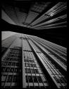 [Reflection of modern office building in window of store across street]