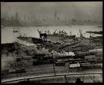 [Docks and railroad yards in New Jersey with view of Midtown Manhattan across the Hudson River]