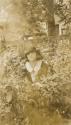 [Girl sitting among flowers]