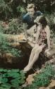[Woman and girl next to lily pond]