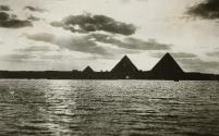 [Pyramids at Giza seen silhouetted from across the Nile]