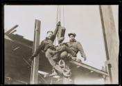 [Men on hoisting ball]
