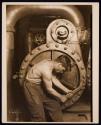 [Mechanic at steam pump in electric power house]