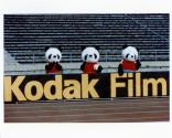 Three China panda bears in front of Kodak Film sign