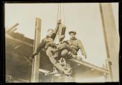 [Men on hoisting ball]
