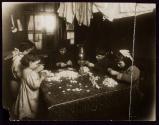 Family making artifical flower wreaths in their tenement...