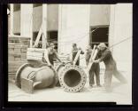 [Plumbers with large pipe elbow, Empire State building]