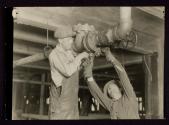 Plumbers fitting pipes in office bldg.