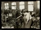 [Men working on machine in textile mill]