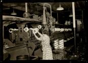 [Textile worker tending machine]