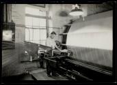 [Man at machine in textile mill]