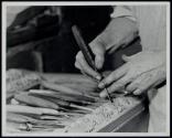[Craftsman making a chair leg design which will be reproduced in multiple]