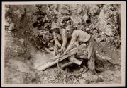 Arthur Roberts and Sam Mynatt, drilling for a shot in boulder in roadway at Norris Dam.