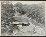 [Flood damaged building by stream]