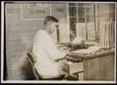 [Sailor at desk typing, Naval training camp]