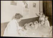[Red Cross medical worker with children in bed, ARC War Relief]