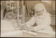 [Red Cross worker cutting bandages with bandsaw, ARC War Relief]