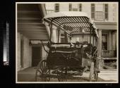 Wagon containing Eastman's camping gear in carriage house yard between carriage house and back porch