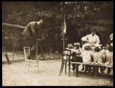 [Lewis Hine photographing children at table in garden - France]