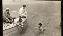 [Men testing water in swimming pool]