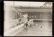 [Men testing water in swimming pool]