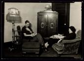 [Young man & woman reading in living room]