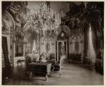 [Interior of room with ornate chandelier, sculptures, and furniture]