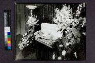 [Baby Nikkie laid out in white coffin]
