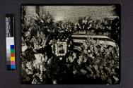 [Portrait of officer by flag-draped coffin]