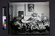 [War veteran laid out beside "Brother" funerary arrangement]