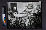 [War veteran laid out beside "Brother" funerary arrangement]