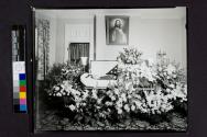 [War veteran laid out beside "Brother" funerary arrangement]