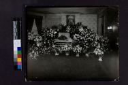 [Man laid out in coffin beneath portrait of Jesus]