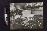 [Woman laid out with "Grandma" floral arrangements]