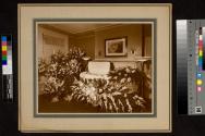 [Man with mustache in tufted casket]