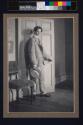 [Alvin Langdon Coburn closing a door, straw hat in hand]