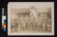[Men in military uniform in front of plane]