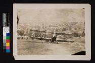 [Plane in field outside town]