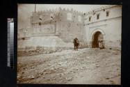 [Man seated on horse outside city wall]