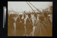 [Men carrying guns in procession]