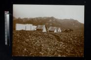 [Tents set up with mountains in background]