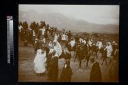 [Group of people, some on donkeys and horses with mountain scene in background]