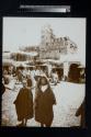 [Young boys standing outside a market place]
