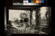 East porch with five wicker chairs and one wicker tables in the center of them