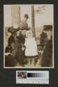 Eastman's companions picnicking in forest, Oak Lodge trip