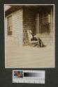 Maria Eastman reading on porch, Oak Lodge trip