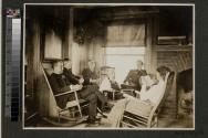 George Eastman and guests inside lodge, Oak Lodge trip