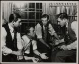 [Men having meeting in library room]